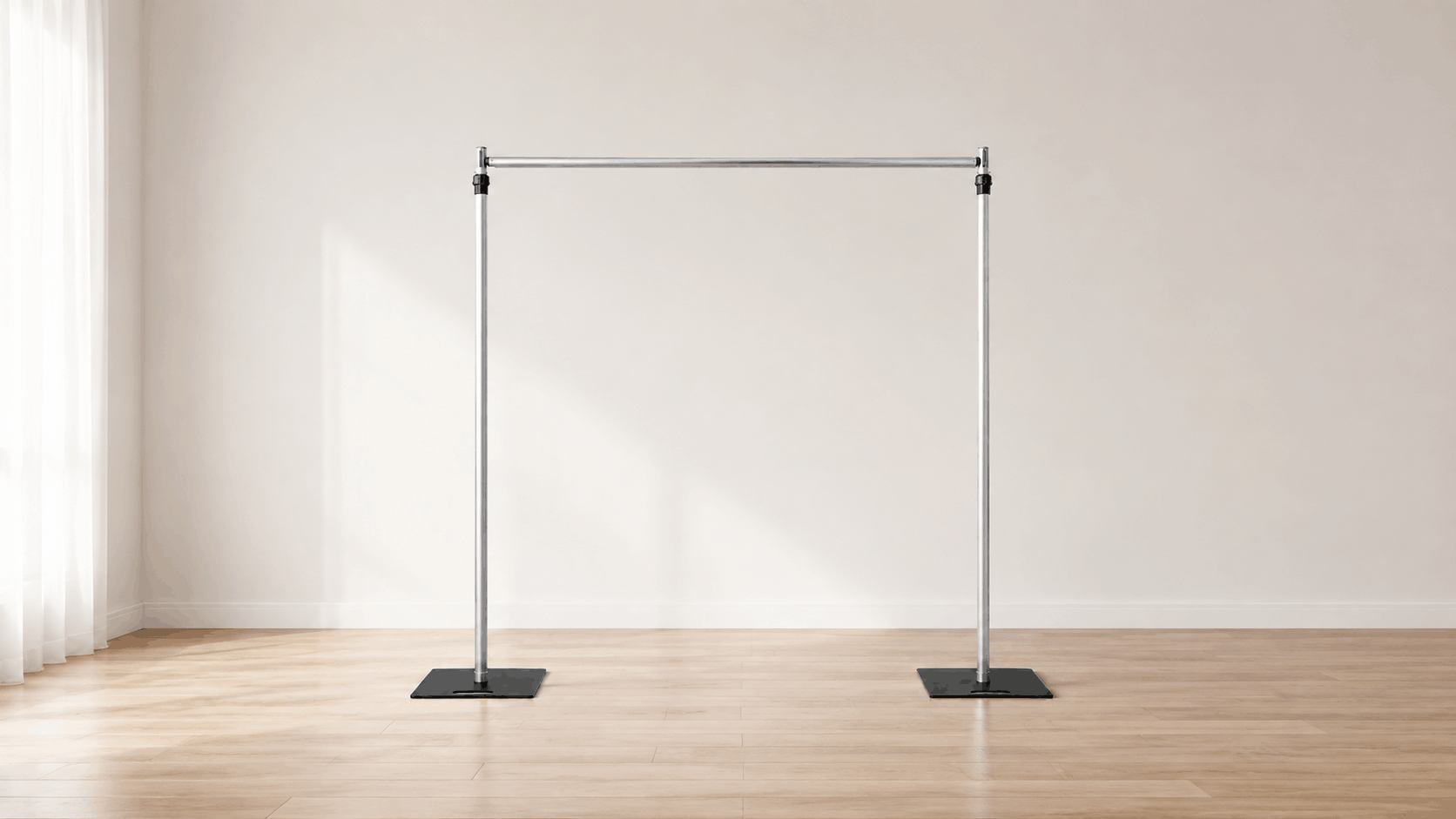 Adjustable pipe and drape backdrop frame in a bright room with hardwood floors, ideal for flower walls, event backdrops, and wedding displays.