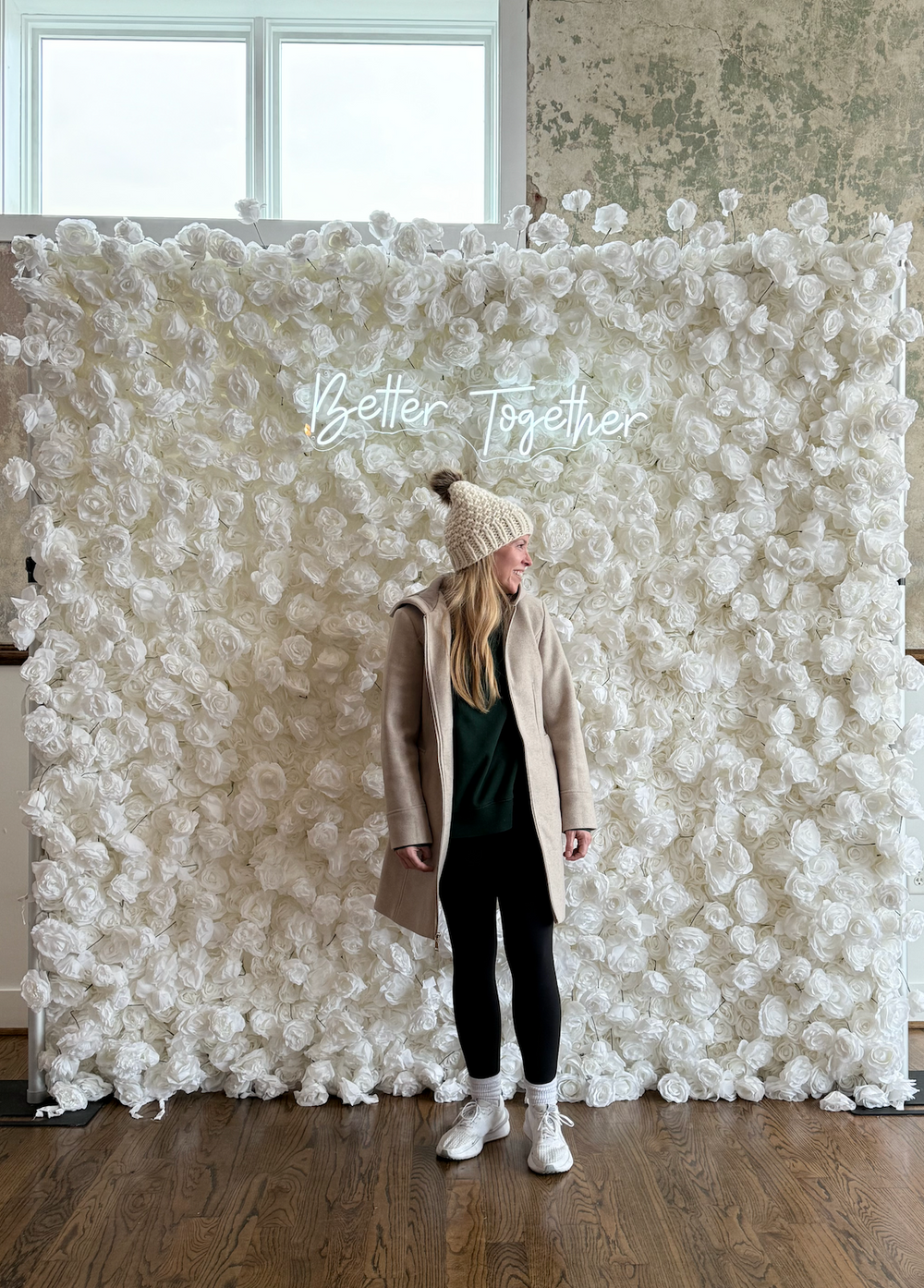 Lilli 3D silk white rose flower wall backdrop with illuminated Better Together neon sign and person standing in front for scale