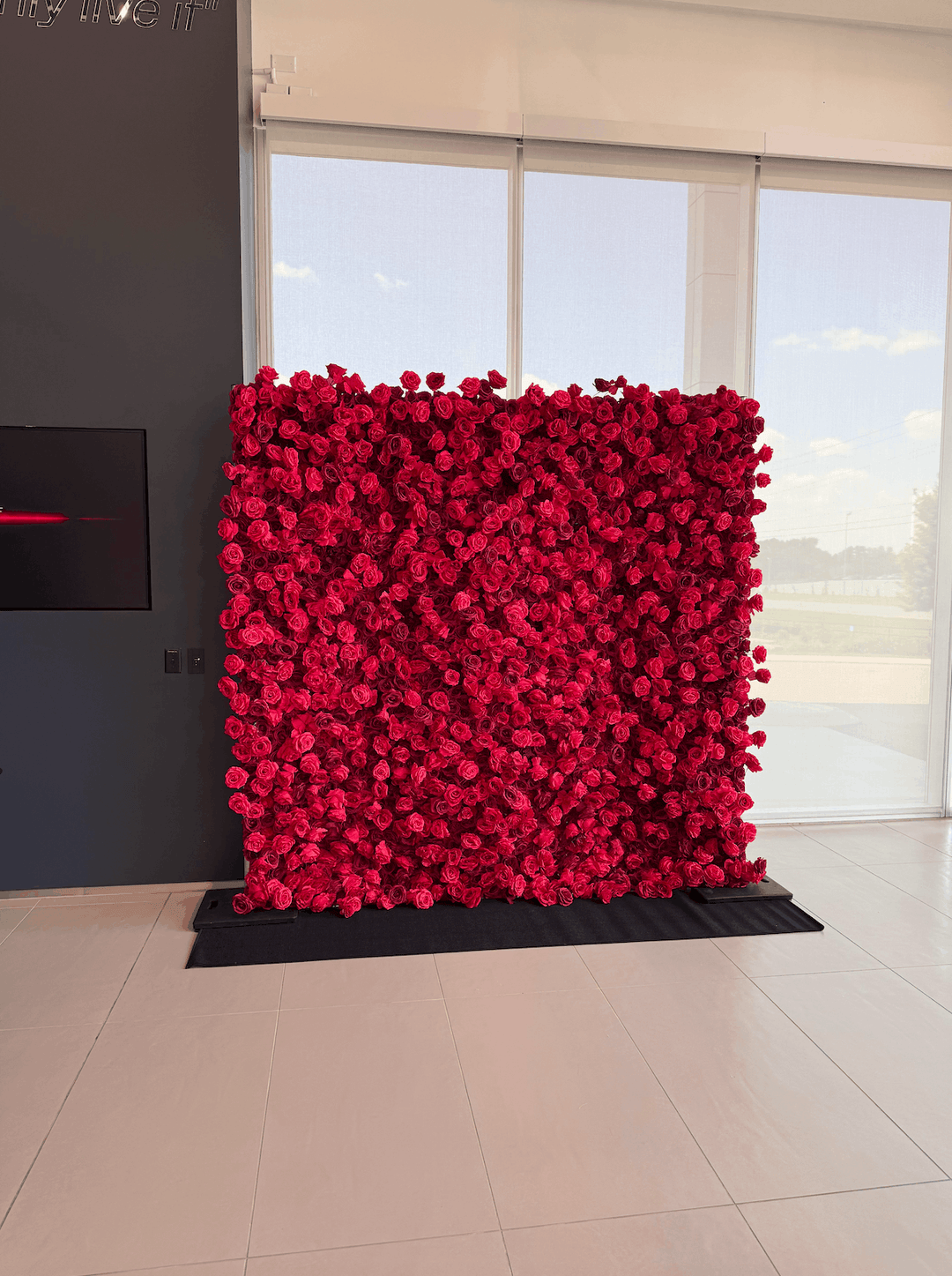 Leigh 3D silk red rose flower wall backdrop installed in a modern indoor venue space.