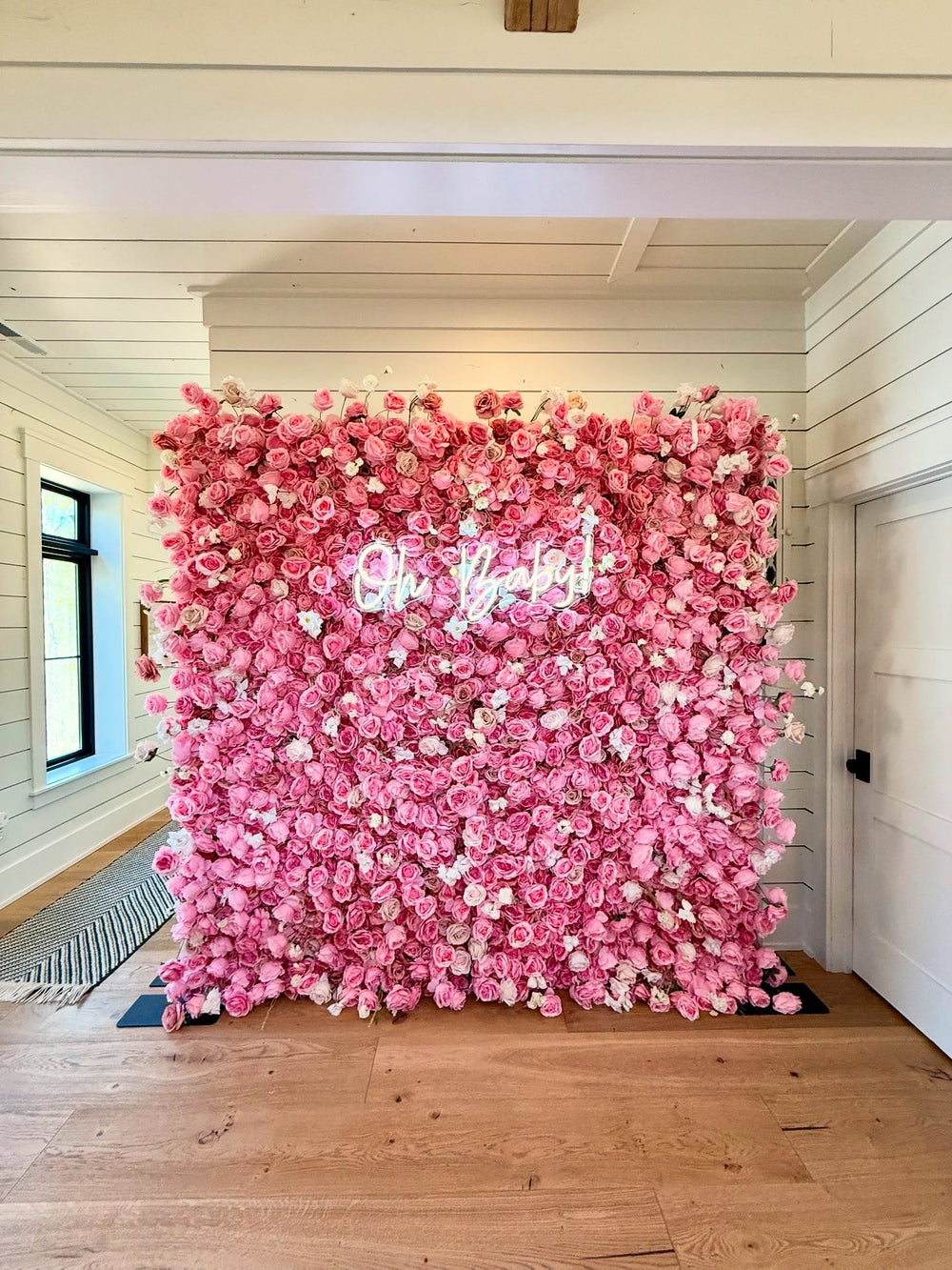 Pink rose and white carnation 3D silk flower wall with illuminated Oh Baby neon sign set up for a girl baby shower backdrop