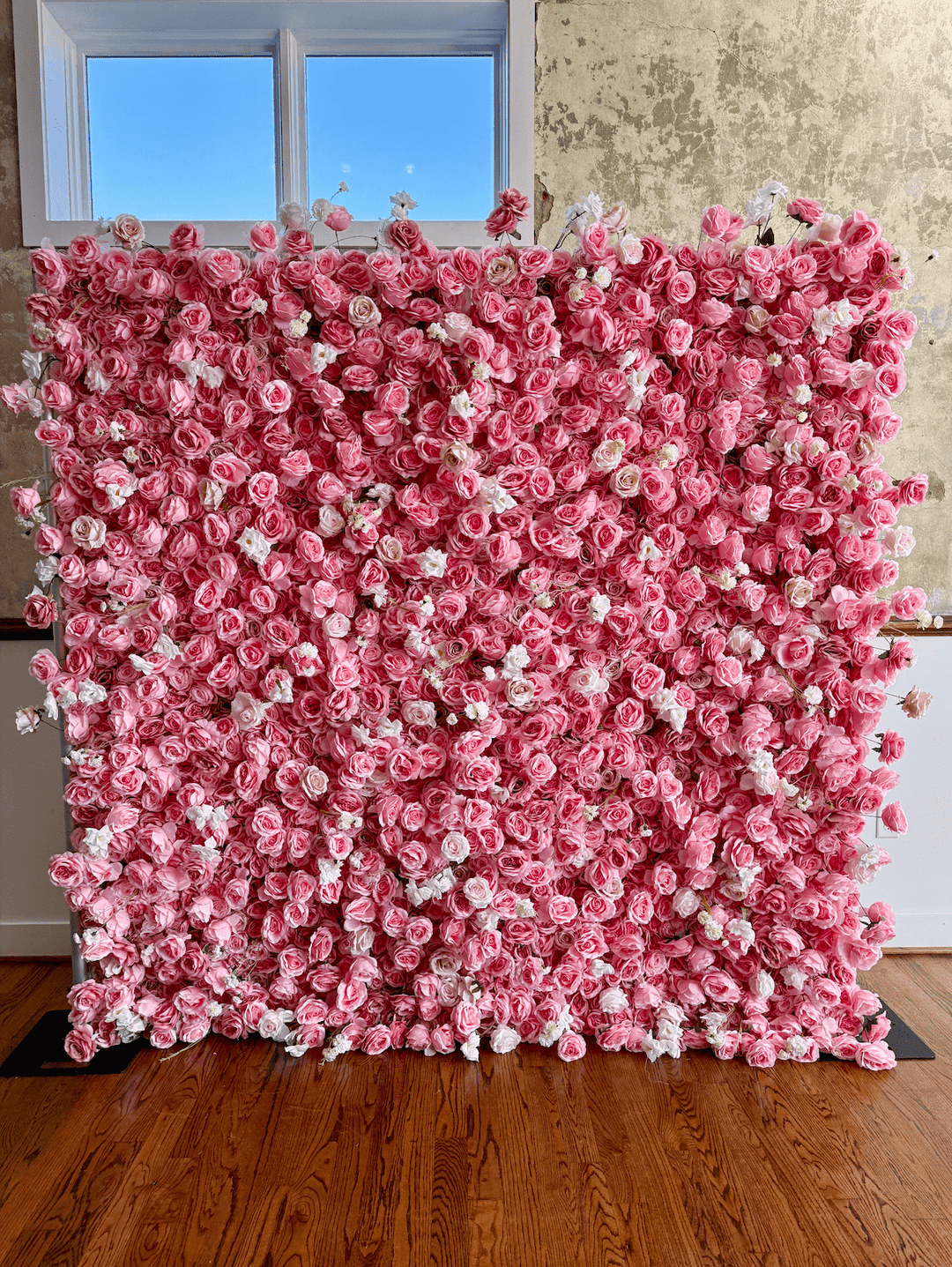 Front view of the 8x8ft pink rose and white carnation 3D silk flower wall backdrop installed indoors