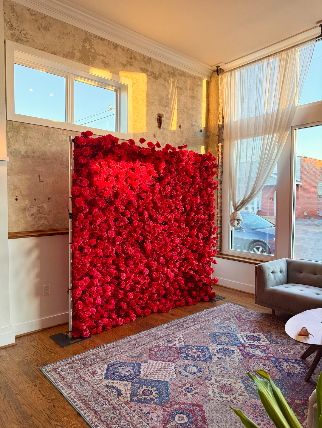 Side profile view of the Leigh red rose 3D silk flower wall mounted on a backdrop frame stand in natural light