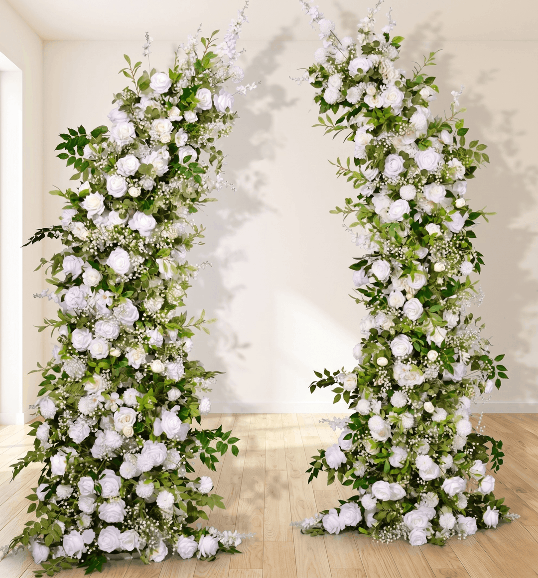 Floral arches decorated with white flowers and greenery in a room.