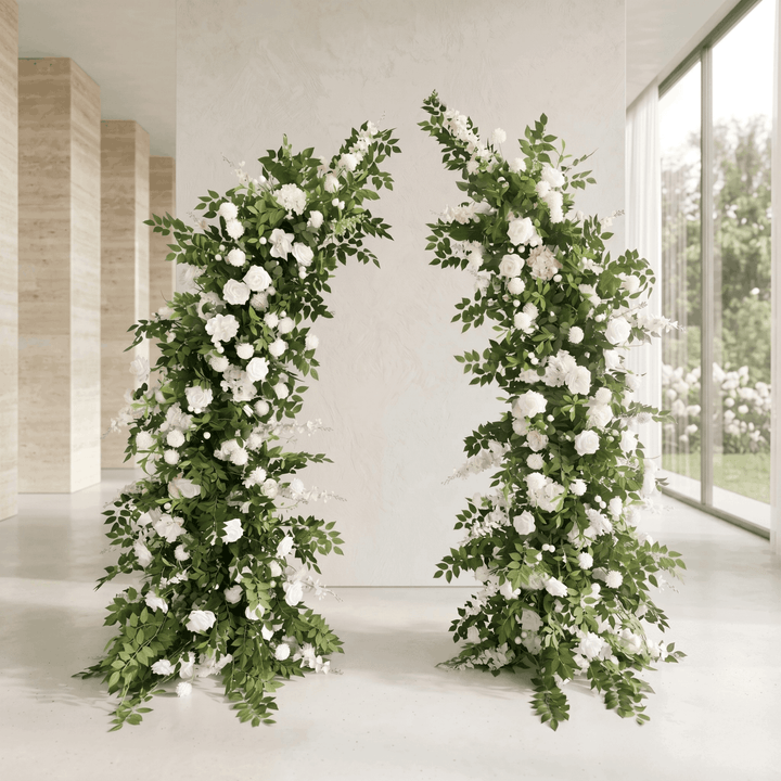Two floral arches decorated with white flowers and greenery in a modern indoor setting.